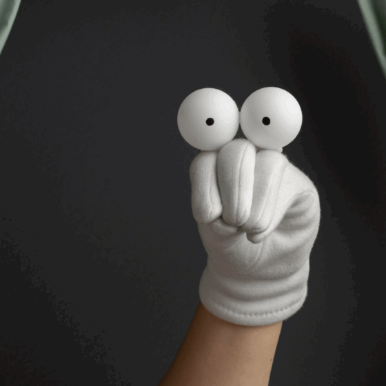 Image d'une marionnette faite avec un gant blanc et 2 yeux sur une main